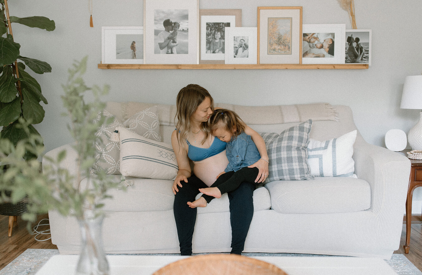 pregnant woman wearing maternity loungewear sitting with her daughter