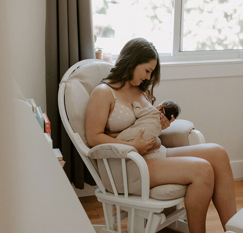 breastfeeding mom sitting on white chair