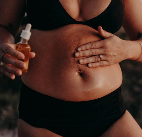 pregnant woman applying skin oil