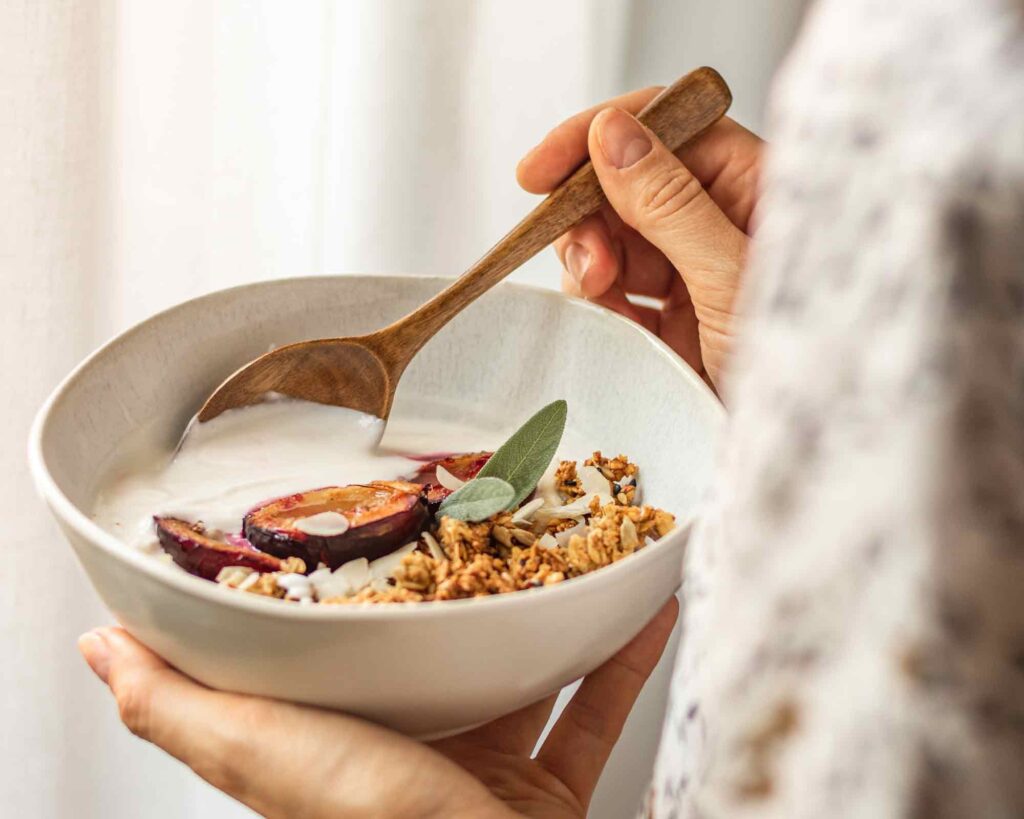 person holding a bowl of granola