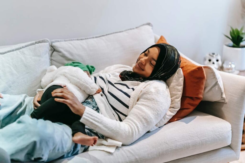 mother breastfeeding child on couch