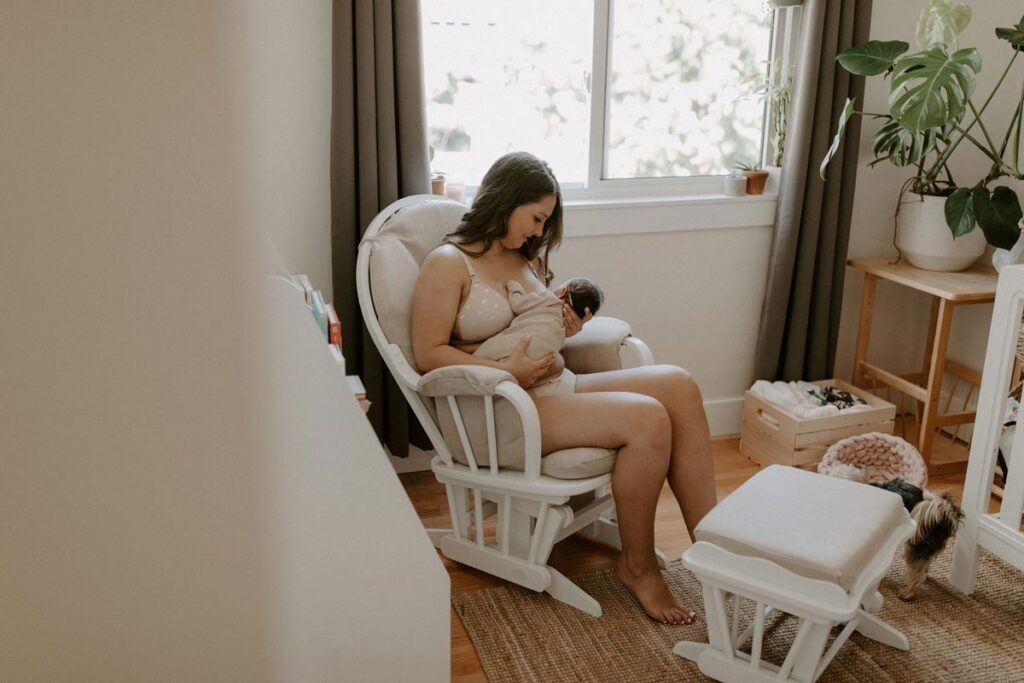 mother on a chair breastfeeding her baby