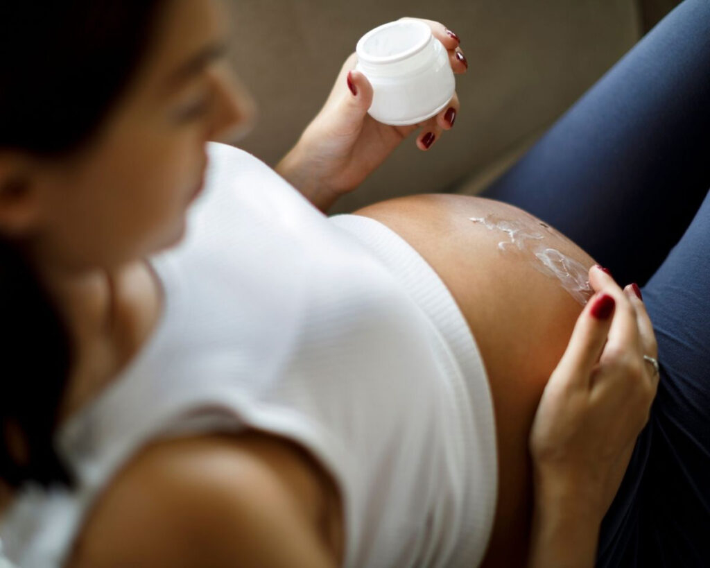 pregnant woman applying cream