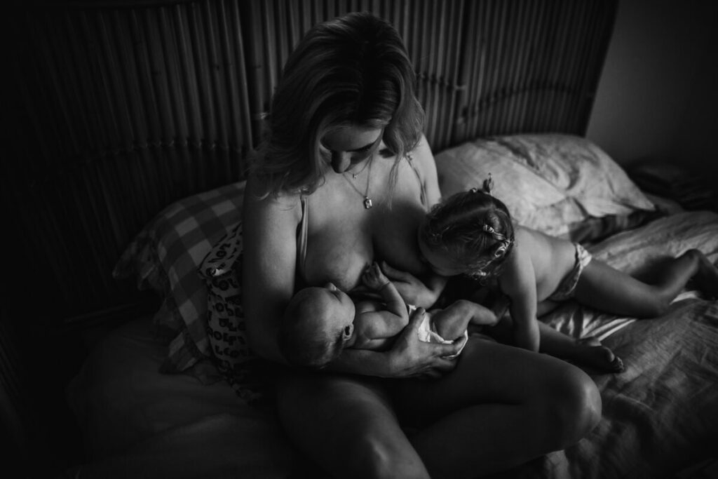 woman tandem breastfeeding in bed